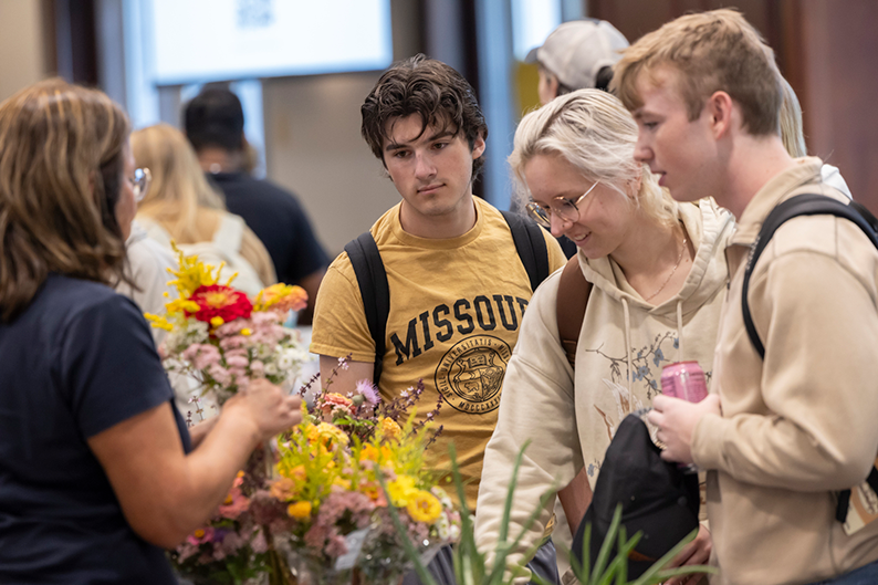  Group of students purchase flowers at the farmers market