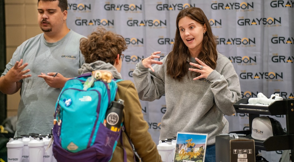  Mizzou student listens to a representative from Grayson Apartments describe lease options at the Mizzou Housing Fair