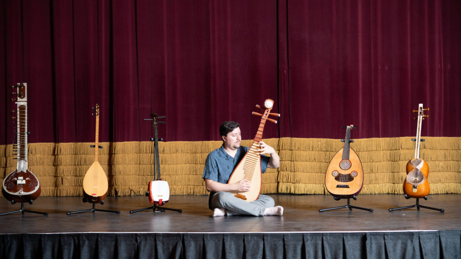  Chris Stephens, musician, sitting on stage at the Missouri Theatre amongst his instruments.